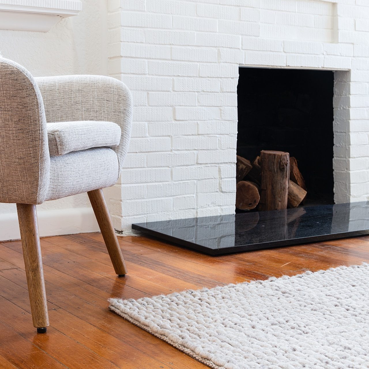 a chair sitting in front of a fireplace in a living room